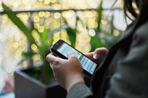 Fotografija osebe, ki uporablja pametni mobilni telefon