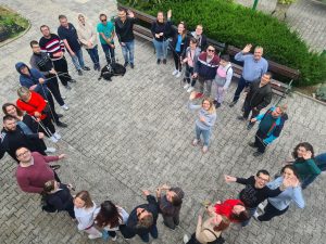 UDELEŽENCI PROJEKTA STOJIJO V KROGU IN MAHAJO FOTOGRAFU